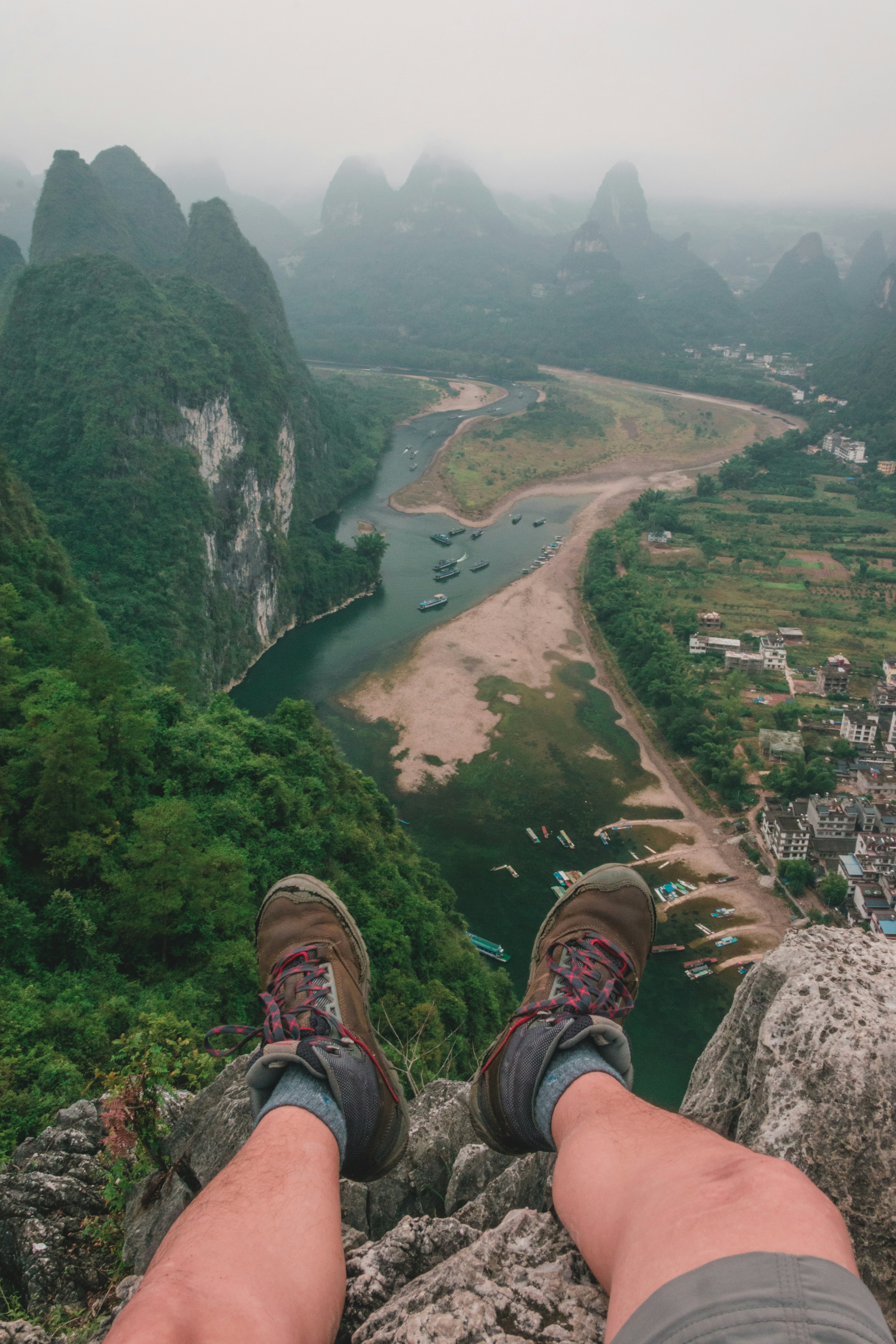 man sitting on rock mountain during daytime