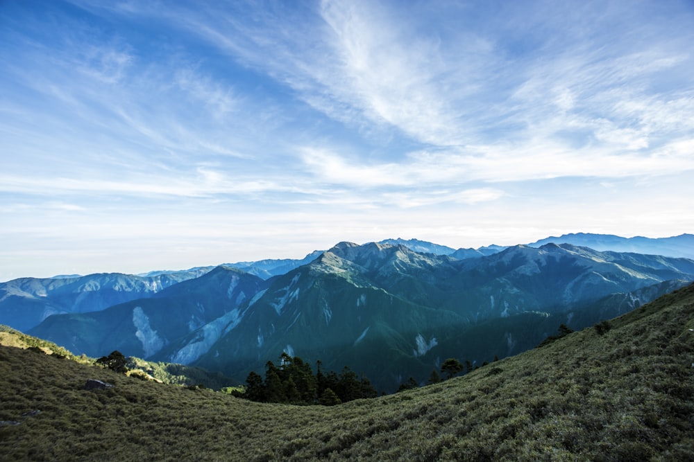 green hills under white and blue sky