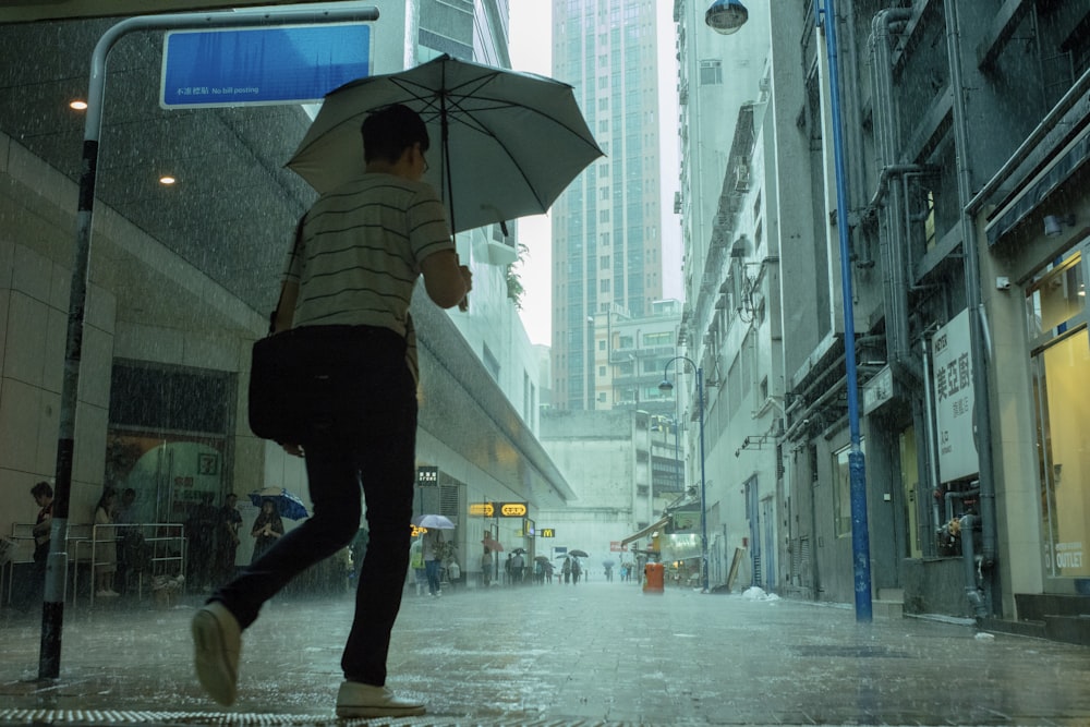 woman walking on street while its raining