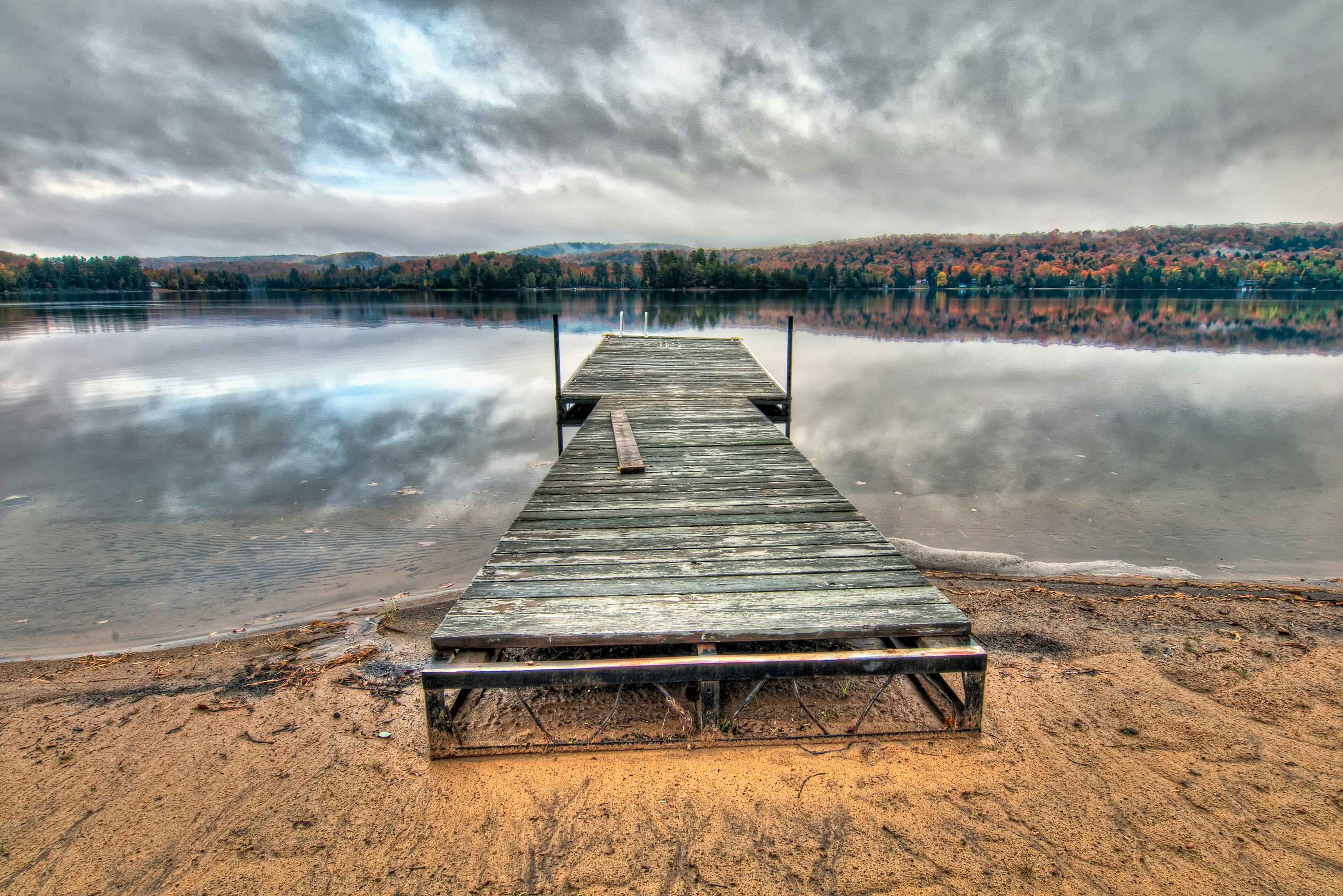 grey wooden dock under dramatic clouds