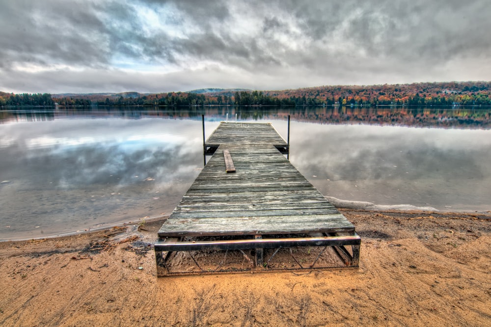 grey wooden dock under dramatic clouds