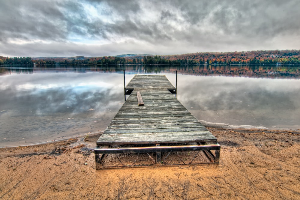 Pontile di legno grigio sotto nuvole drammatiche