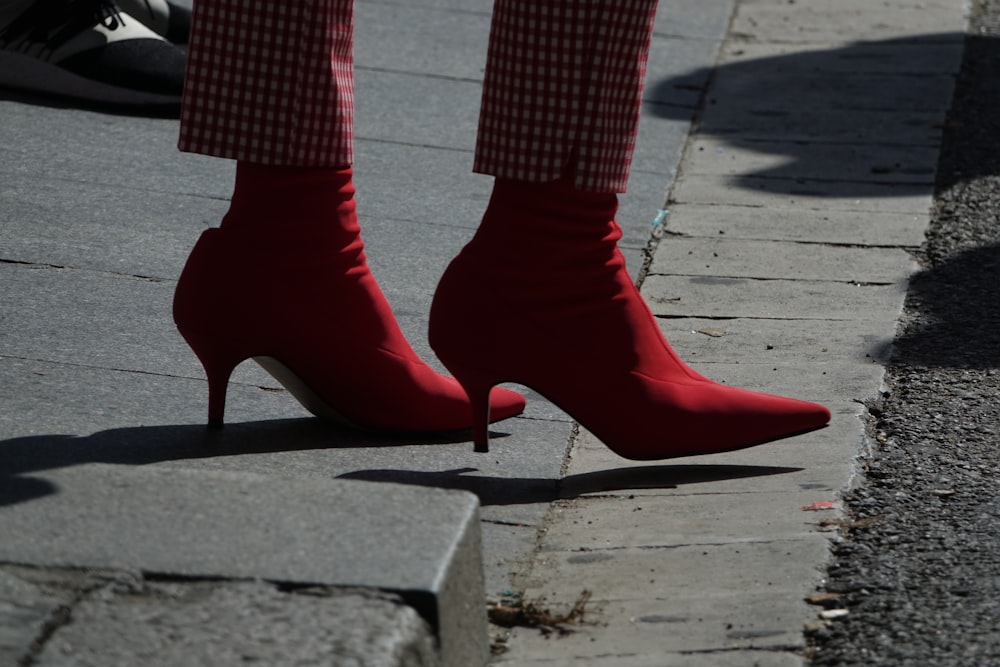person wearing red shoes standing on road