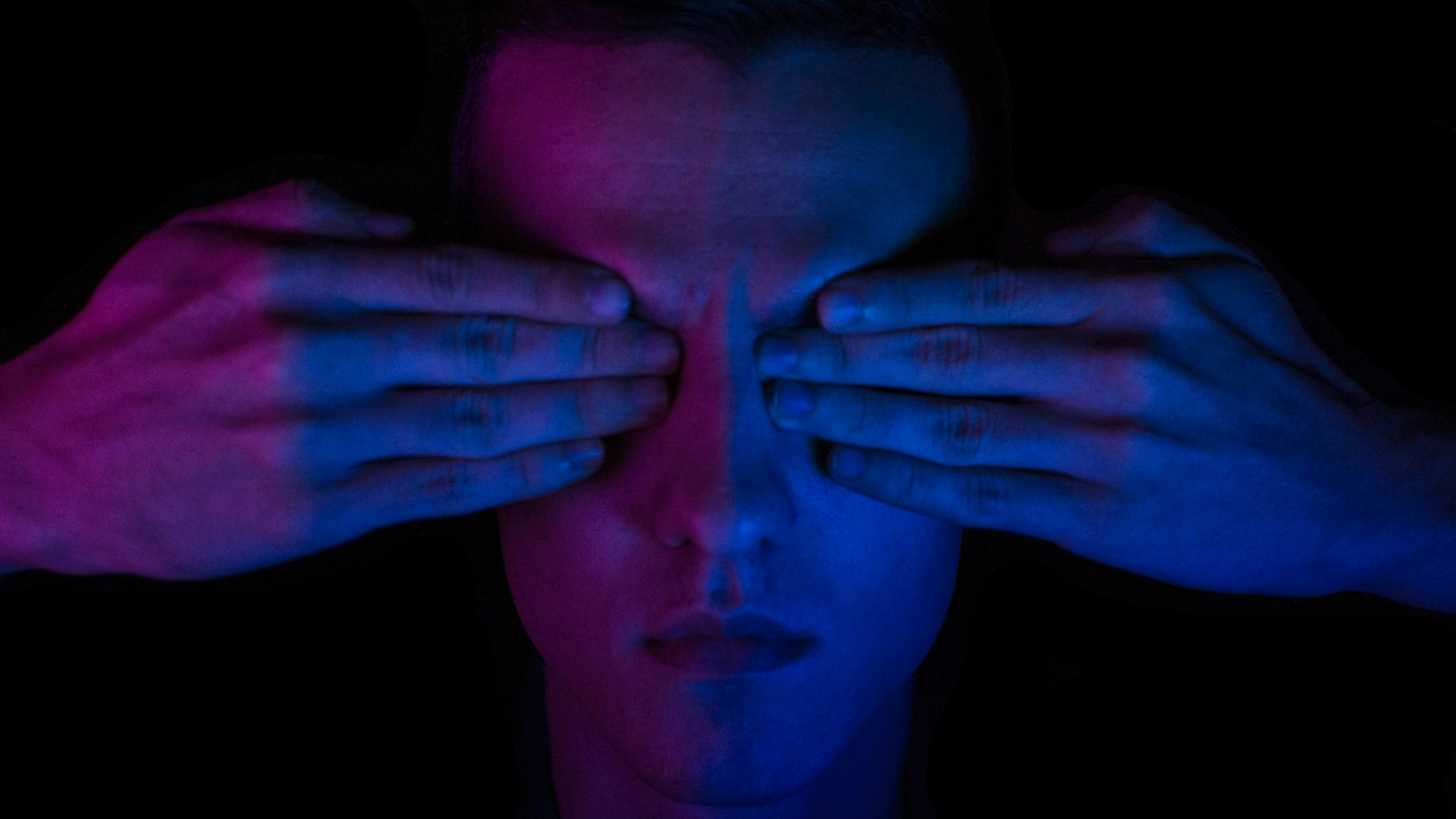 Man with eyes covered; image by Taras Chernus, via Unsplash