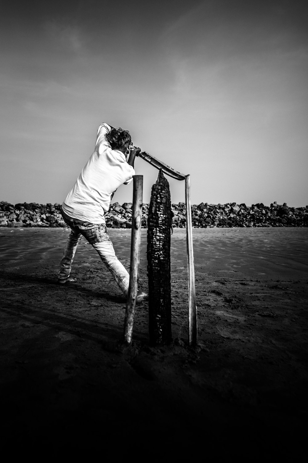 a man leaning against a pole on a field