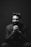 grayscale photography of sitting man wearing suit