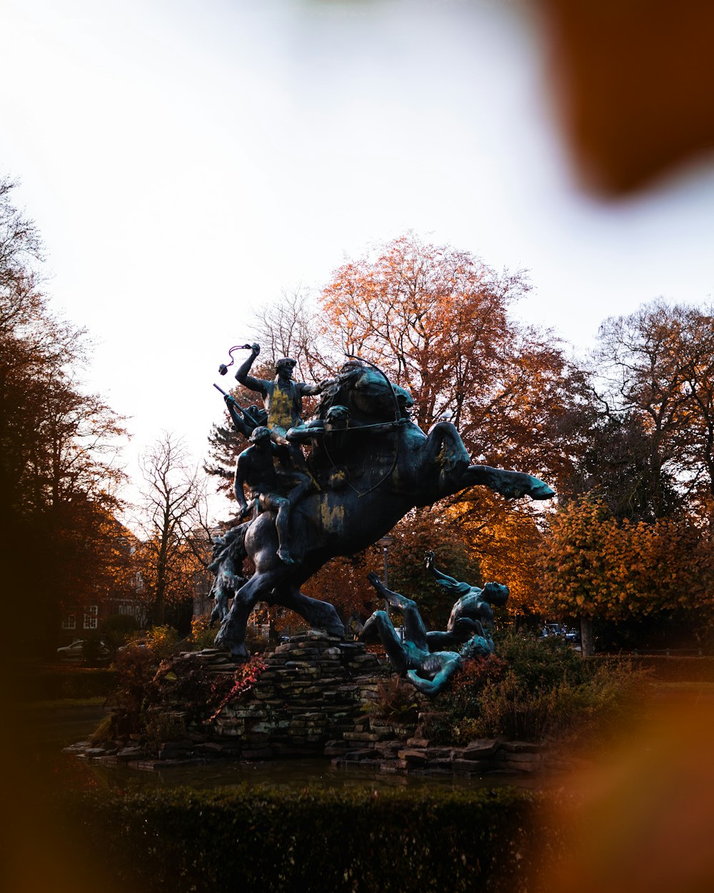 man riding horse statue in the middle of the forest