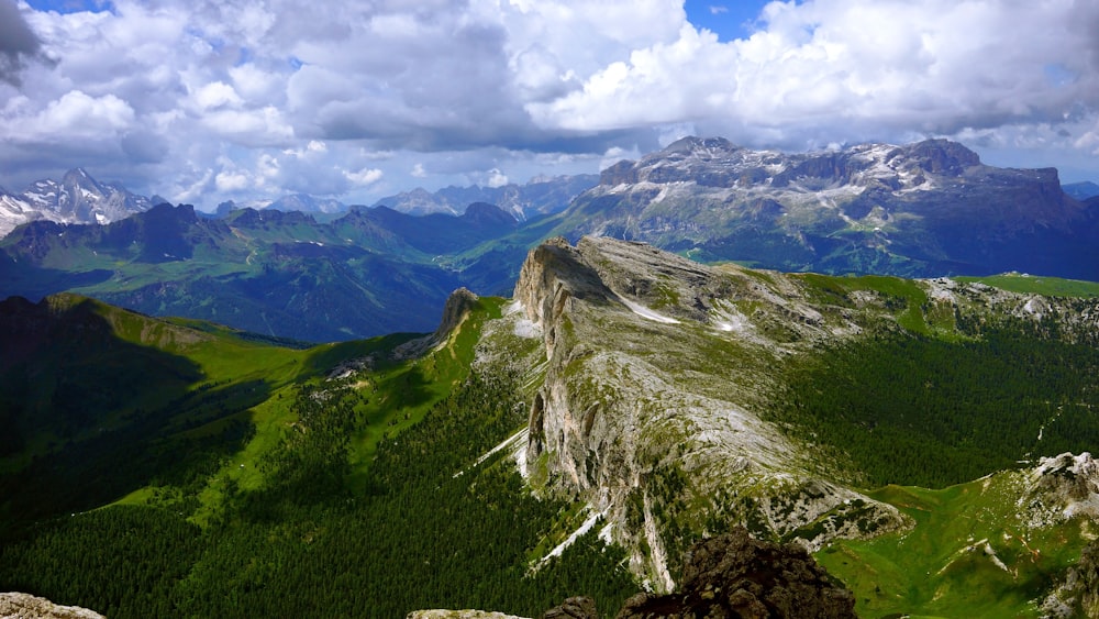 nuages blancs duveteux planant au-dessus des sommets des montagnes