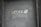 A gray door with the word 'BAKERY' spelled out in black and white letters across the center. The letters appear slightly tilted and unevenly spaced.