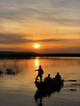 Happy family enjoying a day on a Fibralar boat in a calm lake at sunset.