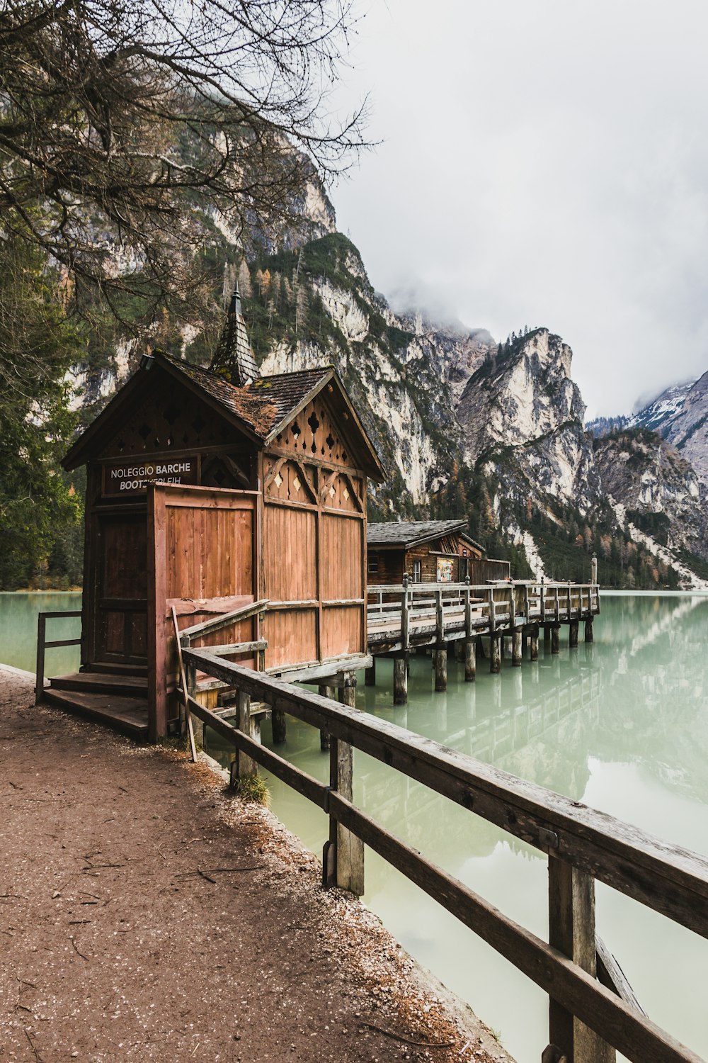 brown wooden shed on dock near body of water