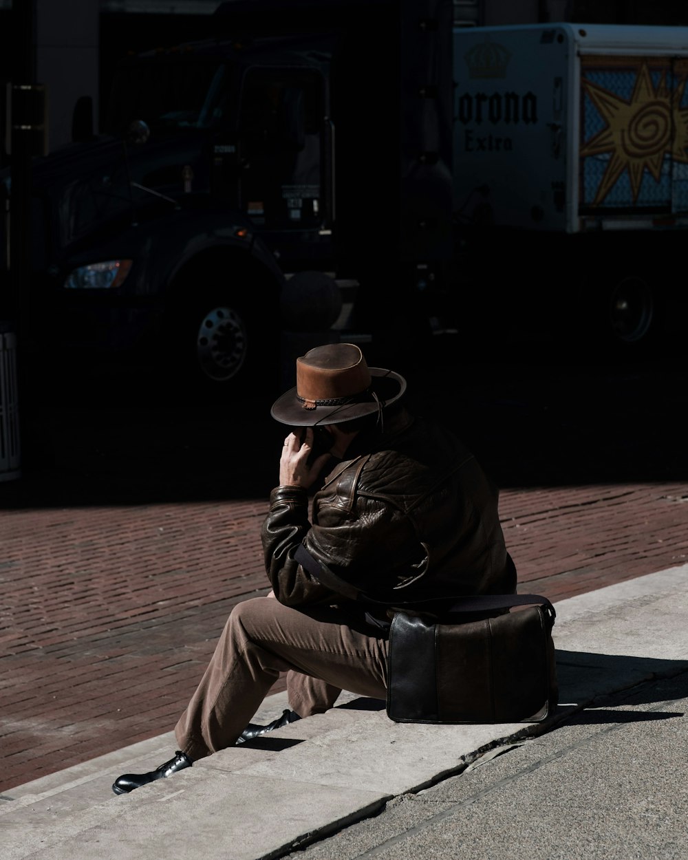 man sitting on ground calling on phone