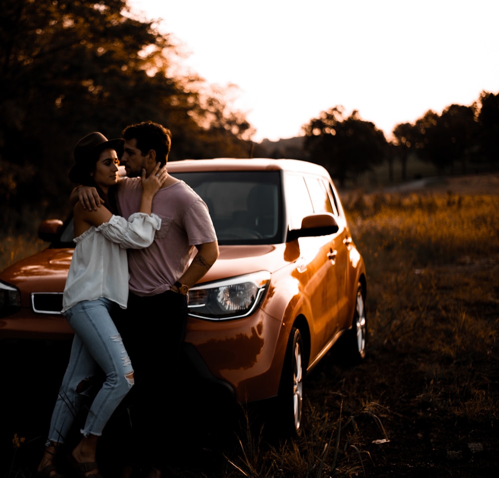 couple learning on brown SUV during s