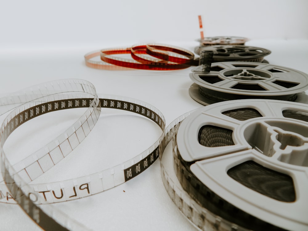 Quatre bobines de films couchées sur une table blanche