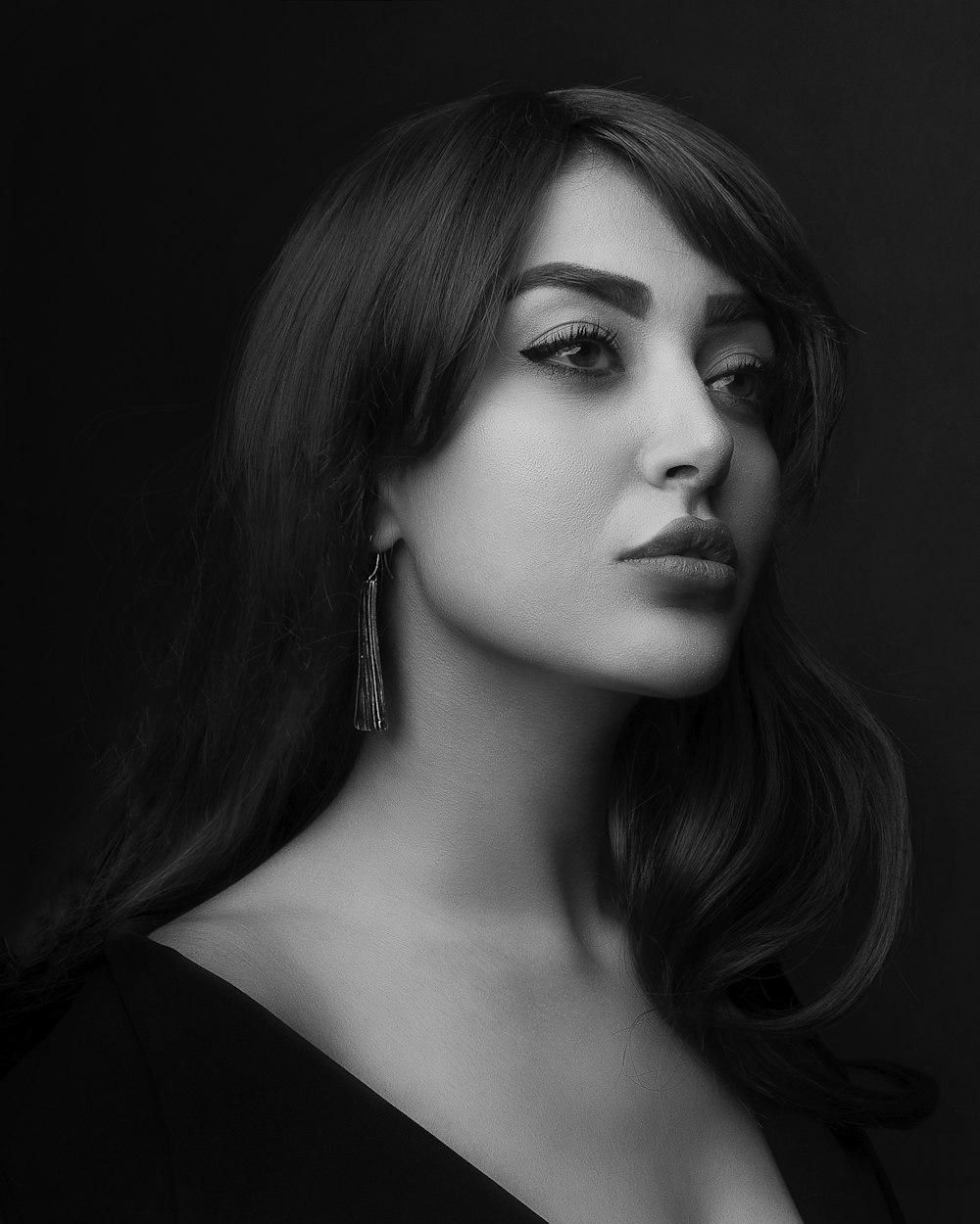 grayscale photo of woman wearing black top in black background