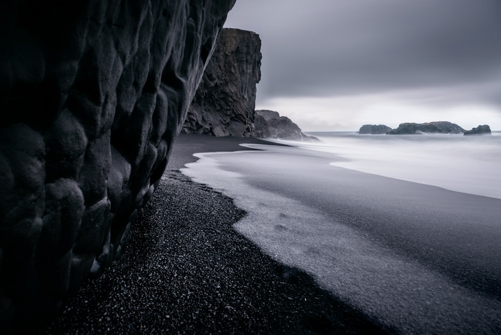 해변과 잔잔한 바다의 그레이스케일 사진