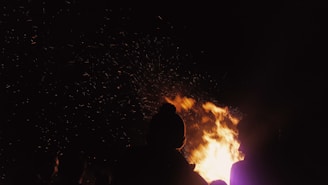 A vibrant community gathering outdoors with diverse people sharing stories and laughter around a bonfire at sunset.