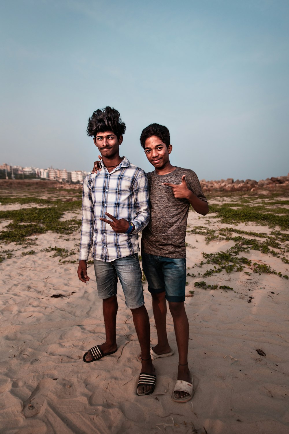 two men standing on white sand