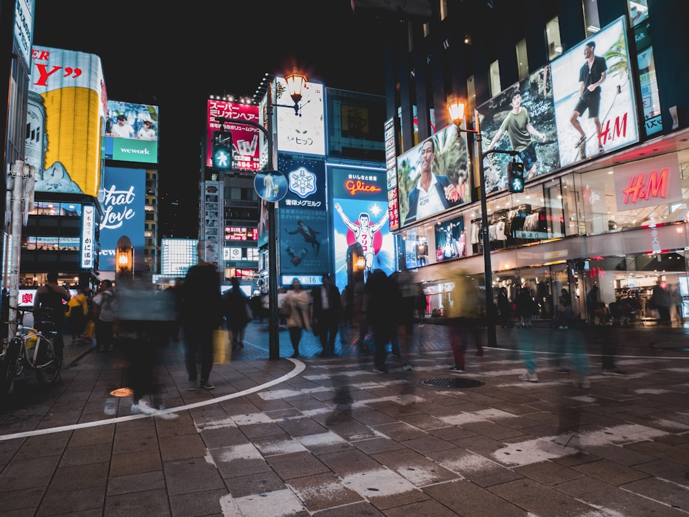 a group of people walking down a street at night