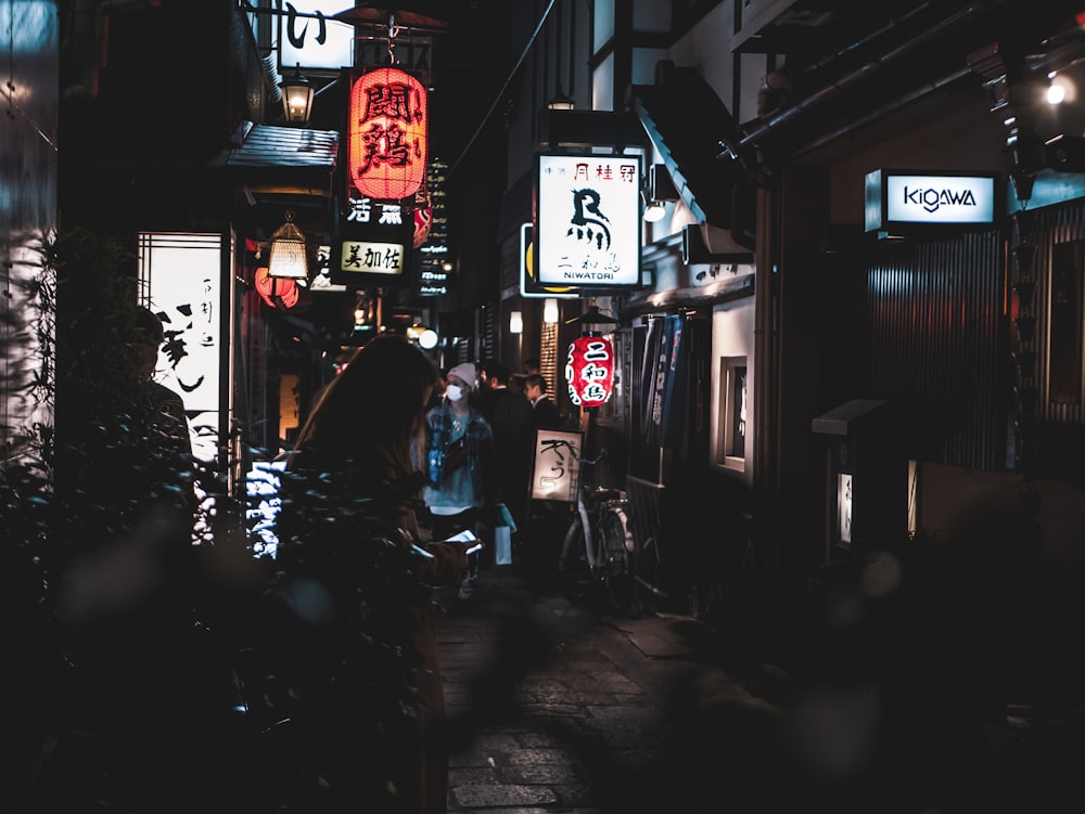 a group of people walking down a street at night