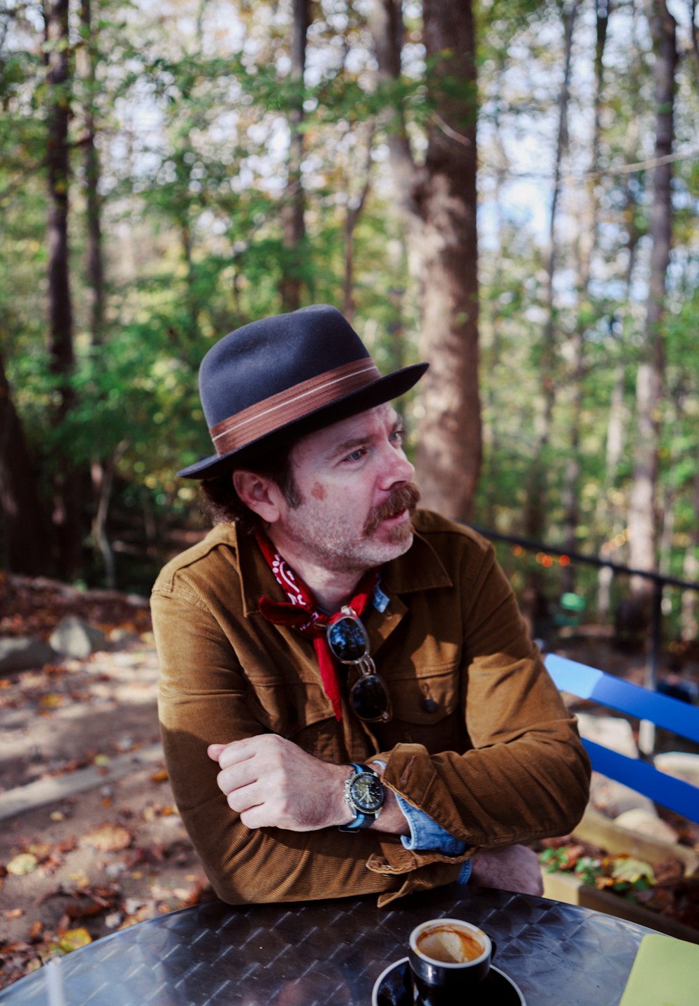 man in brown jacket lean on table