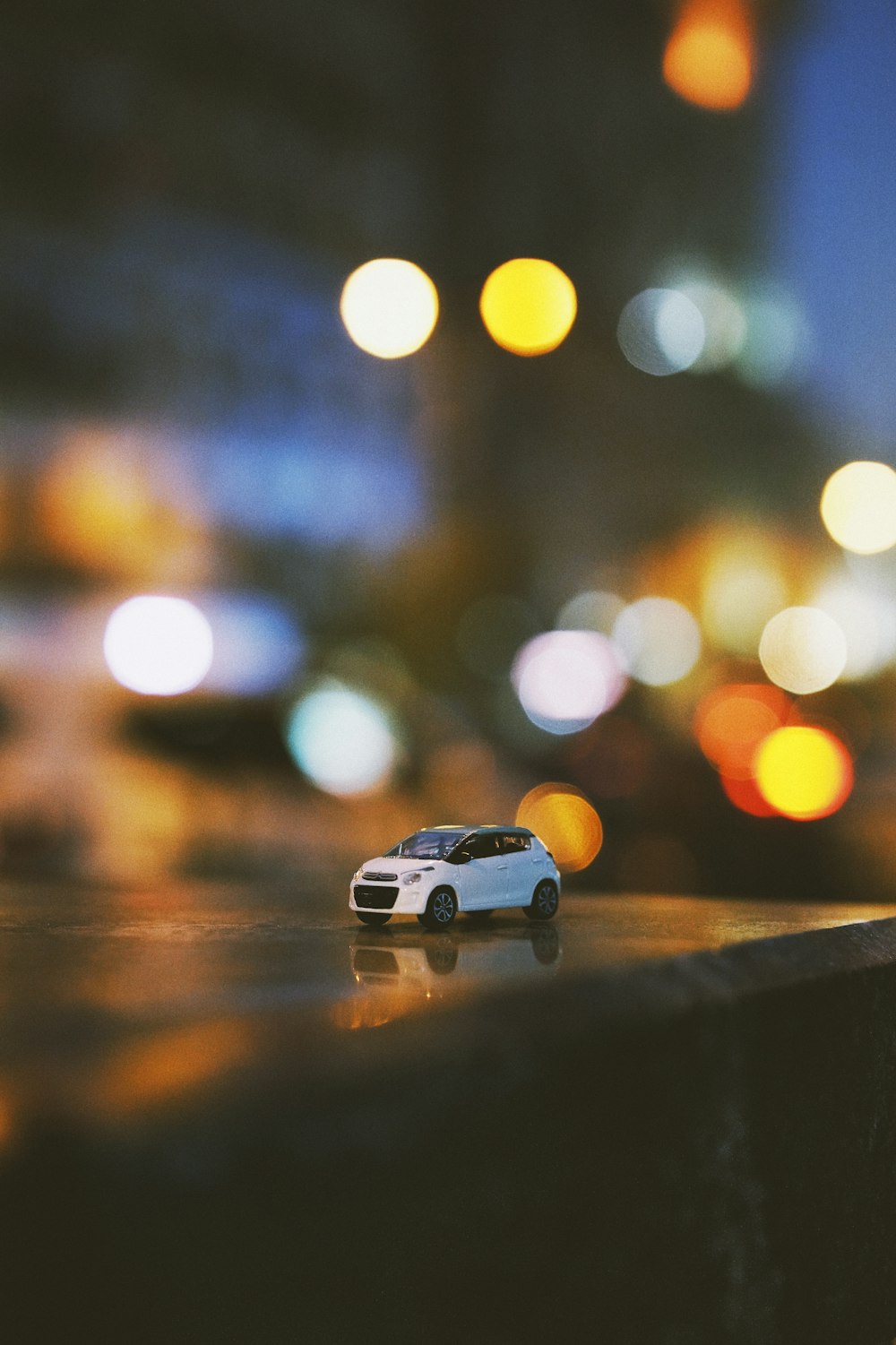 bokeh photography of white car miniature