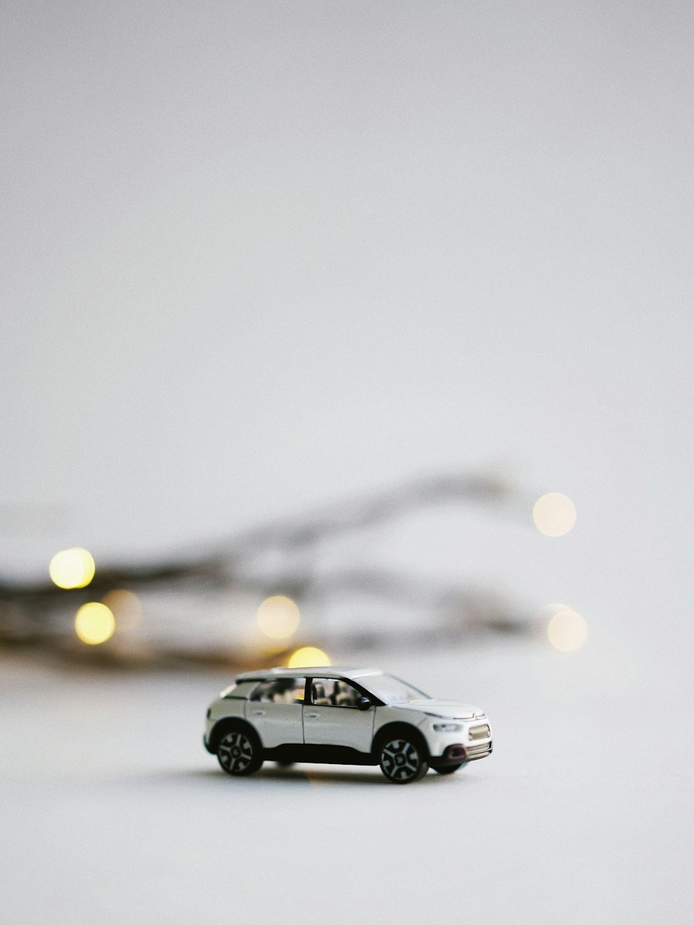 photographie de mise au point sélective d’une miniature de SUV blanc