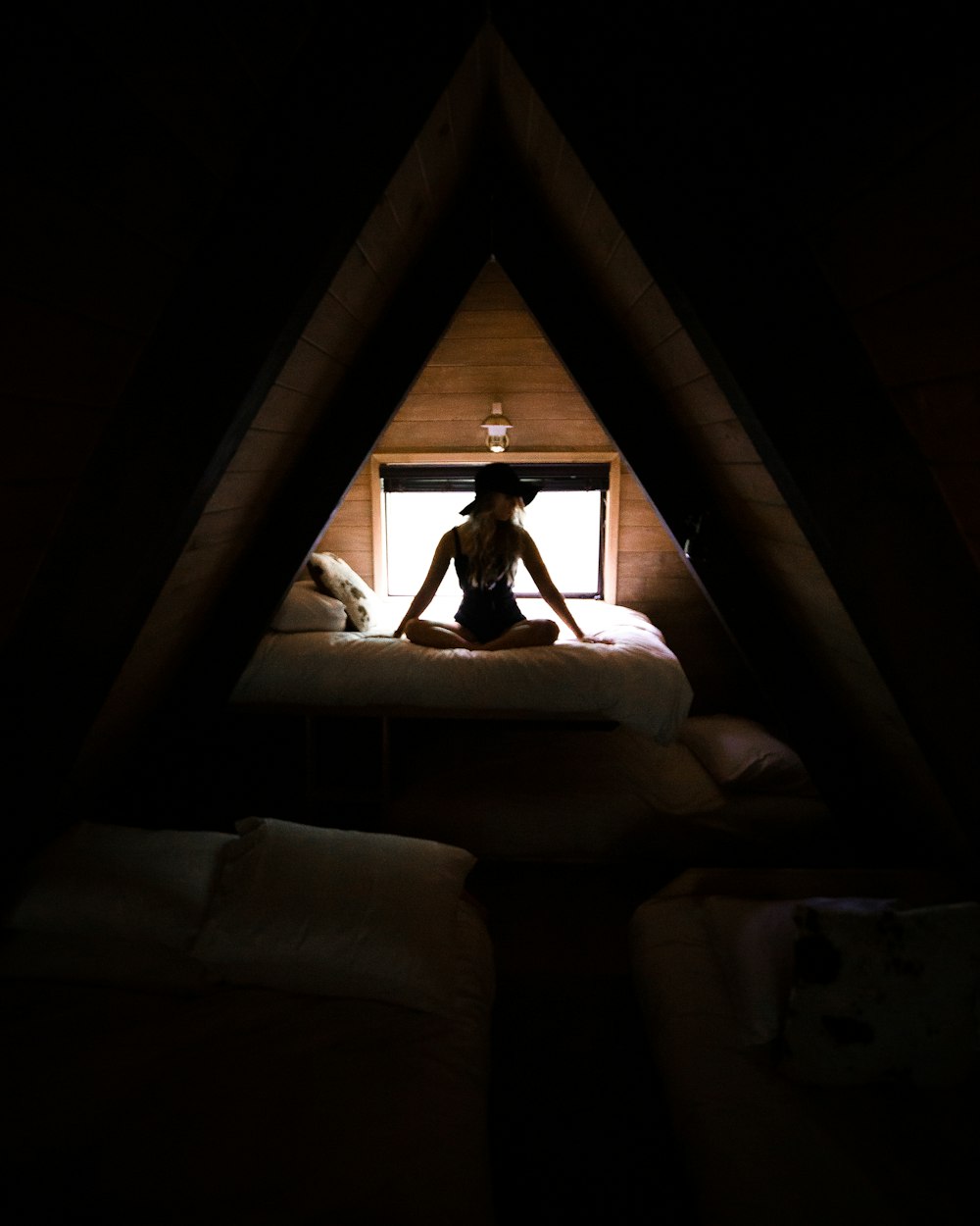 Silhouettenfotografie einer Frau, die auf dem Bett sitzt