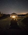 A couple enjoying a romantic dinner on their villa’s deck under a starlit sky.