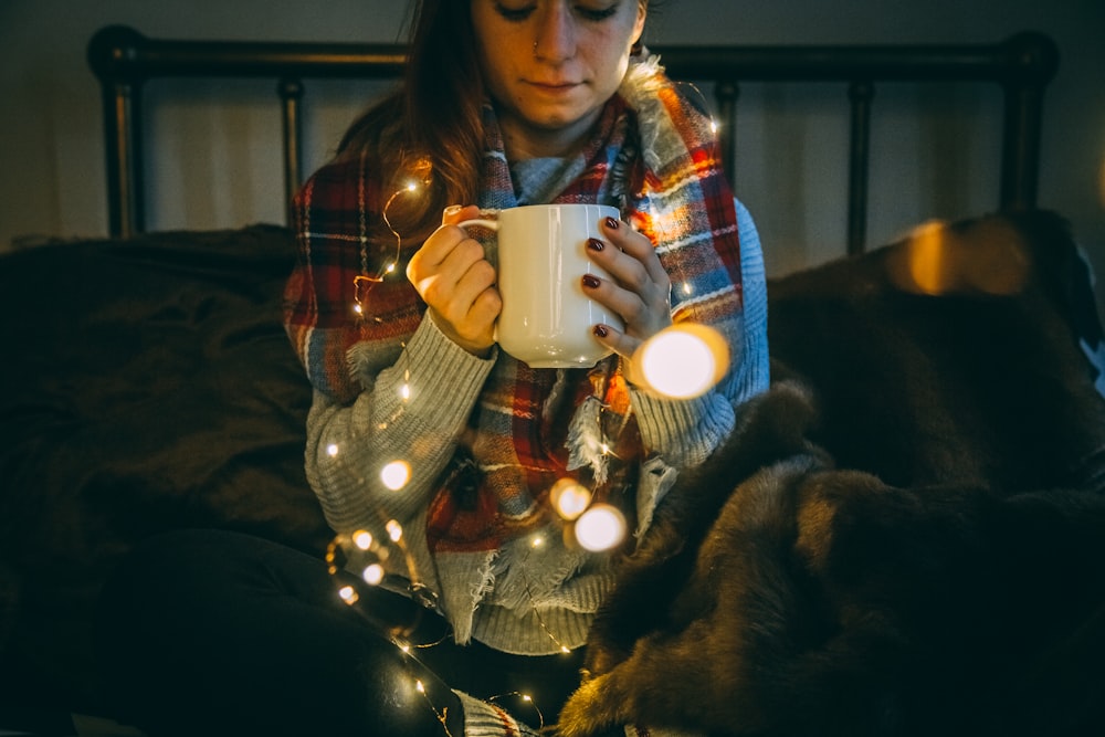 mujer sosteniendo taza blanca