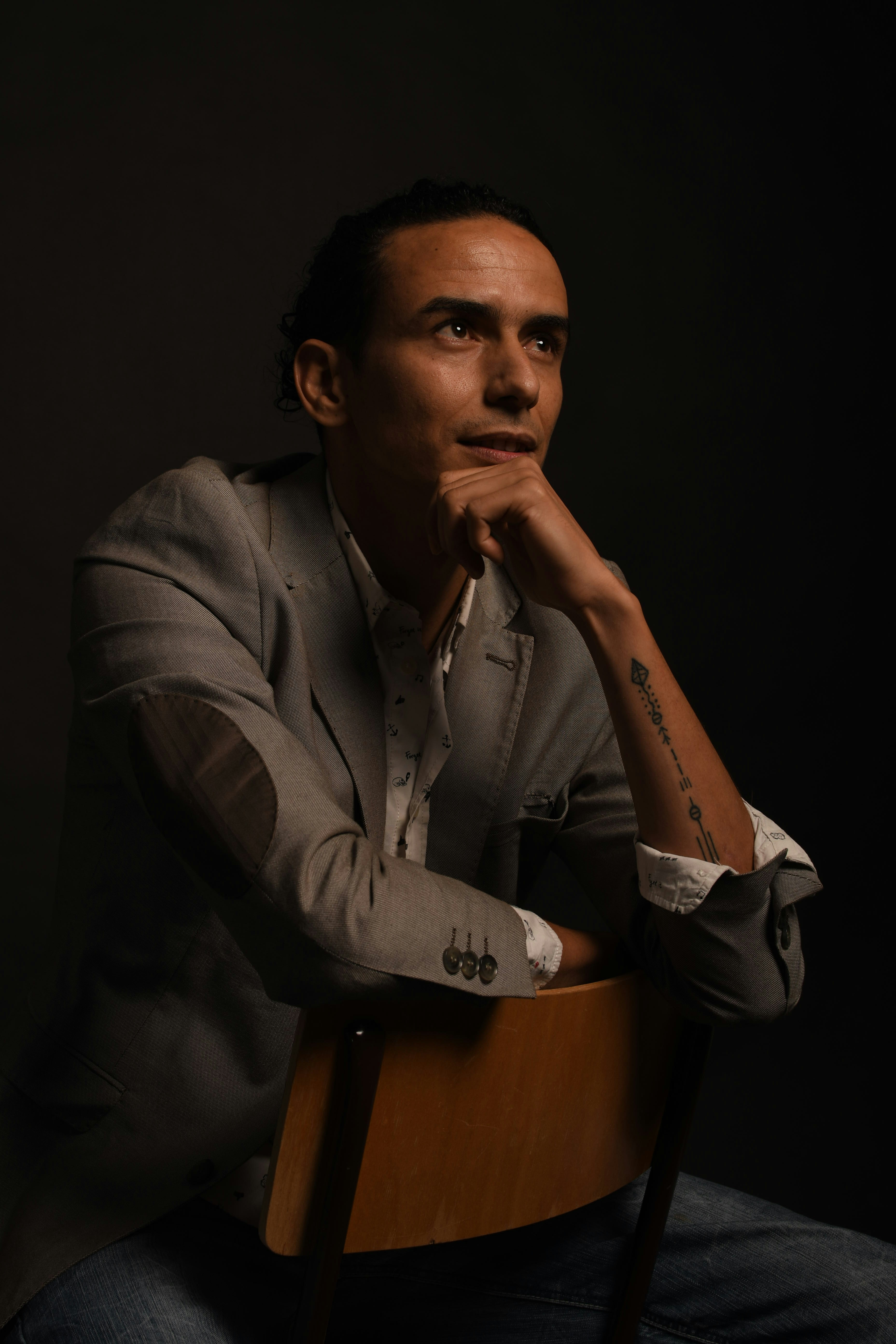 Man in grey suit jacket sitting on chair photo – Free Black Image on