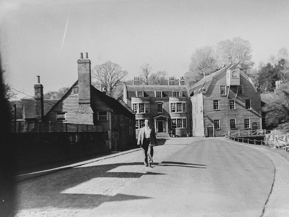 man walking alone on road near houses