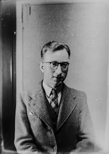 man in coat greyscale photo