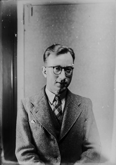 man in coat greyscale photo