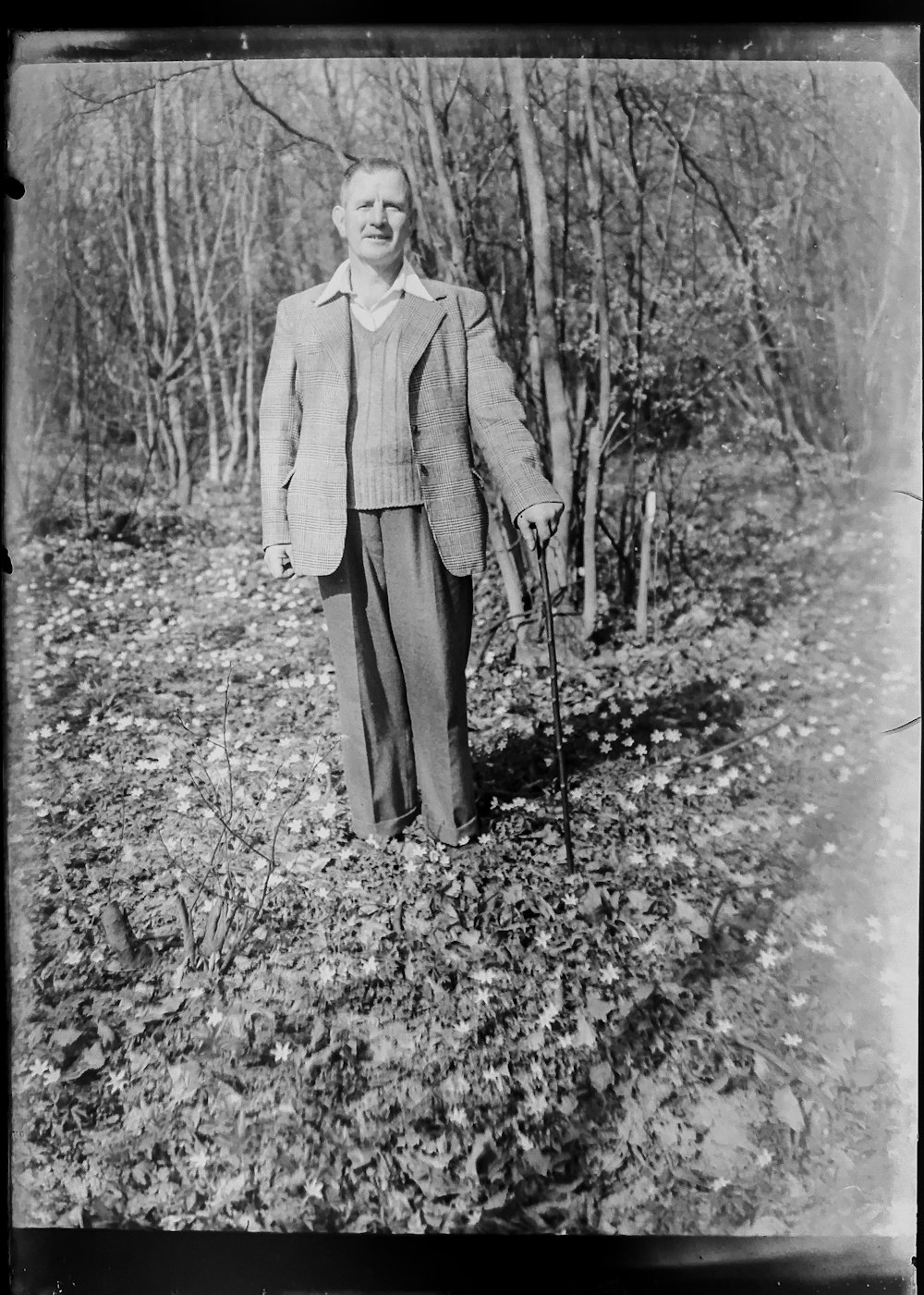 grayscale photography of man standing near trees