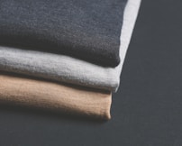 piled of black, gray, and brown clothes