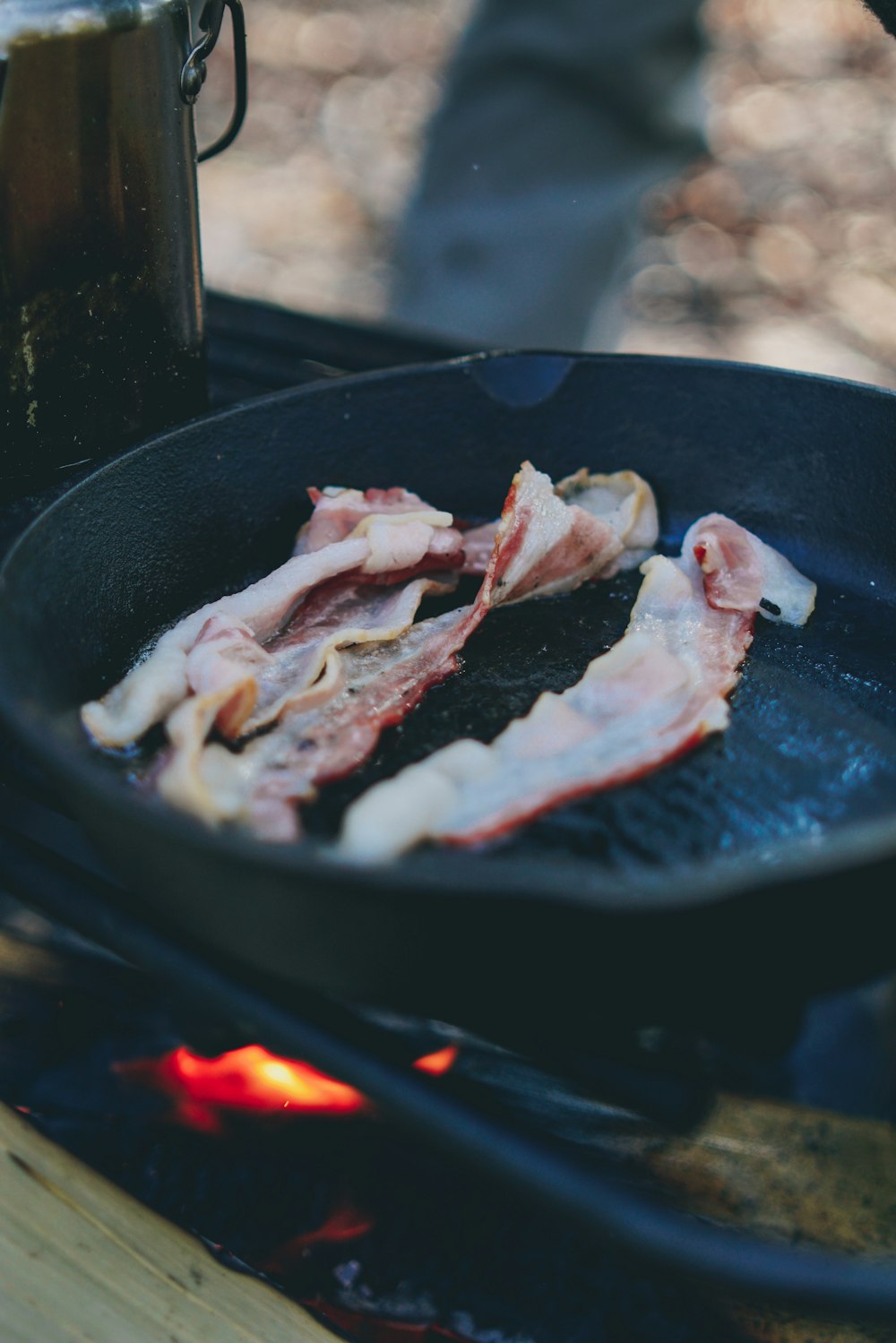 strisce di pancetta su padella in ghisa nera