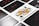 A close-up view of playing cards laid out in a grid pattern, with a prominent Queen of Spades card in the center. The other cards include assorted numbers and suits, all arranged neatly.