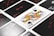 A close-up view of playing cards laid out in a grid pattern, with a prominent Queen of Spades card in the center. The other cards include assorted numbers and suits, all arranged neatly.