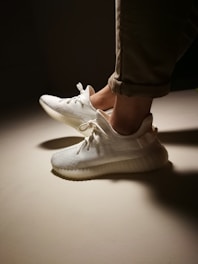 A pair of sleek, versatile chinos rolled up at the ankles on a wooden floor.