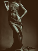 Sepia-toned vintage nude portrait of a woman with soft lighting and delicate shadows.