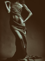 An editorial shot of a silhouette framed by warm nude tones, evoking sensual confidence in slow luxury.