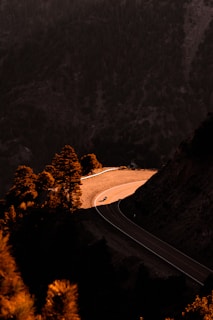 A winding mountain road bathed in golden afternoon light, perfect for a motorcycle ride.