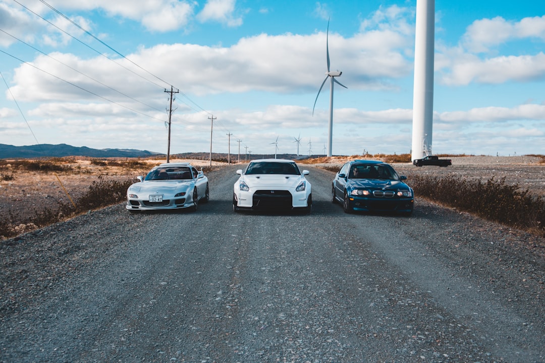 three white and black vehicles on road during daytime