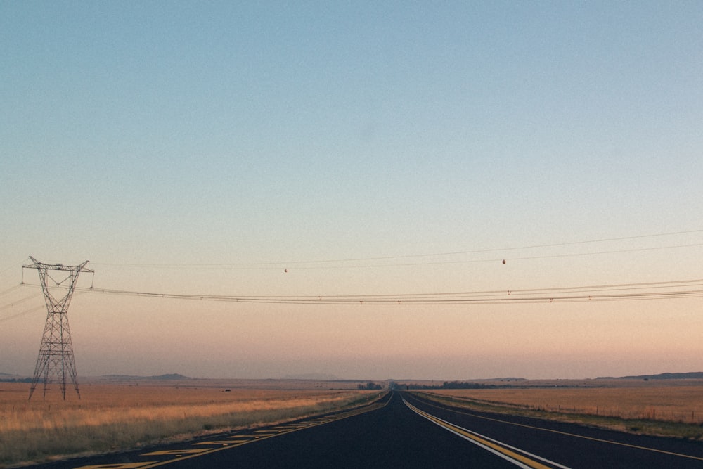 Carretera vacía entre campos de hierba marrón durante el día