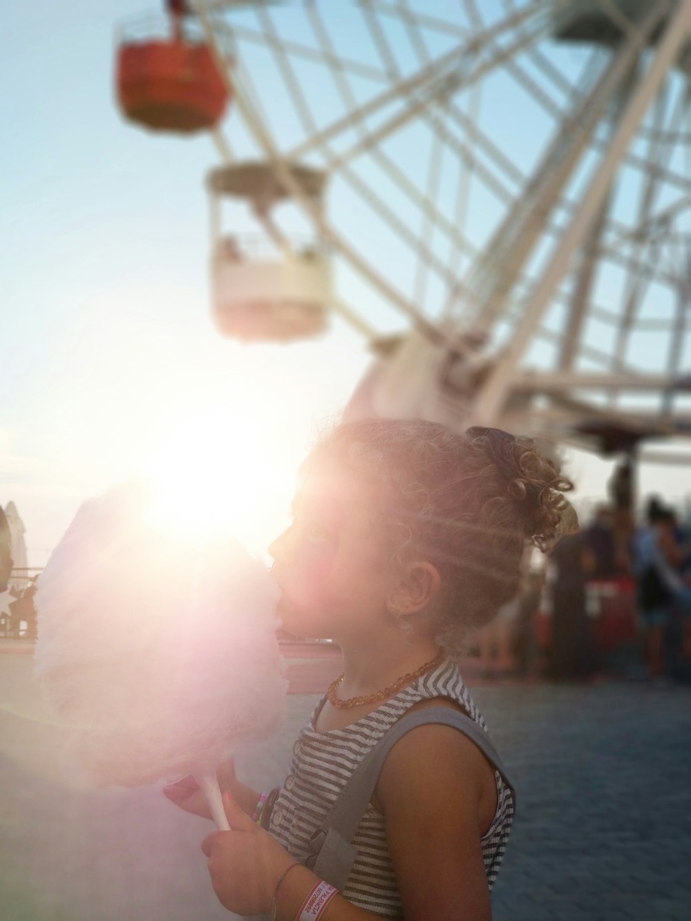 girl holding stick of pink candy floss