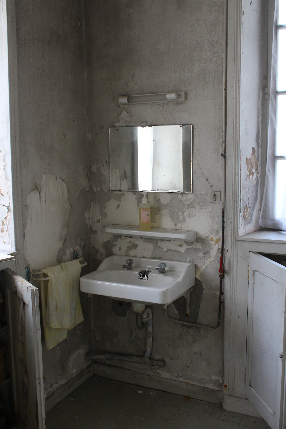 Dated bathroom with an old basin and worn fittings