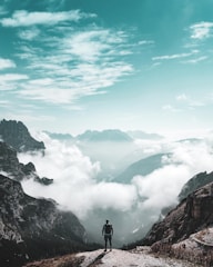 man on hill near mountains