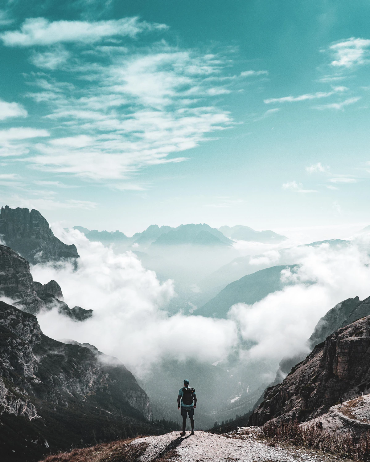 Traveler on a hilltop overlooking a mountain range
