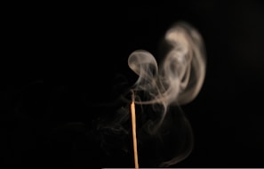 Aromatic amber dust releasing warm smoke as it softly smolders